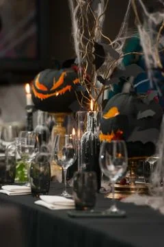Table set for Halloween dinner. Served holiday table with candles and pumpkin Stock Photos