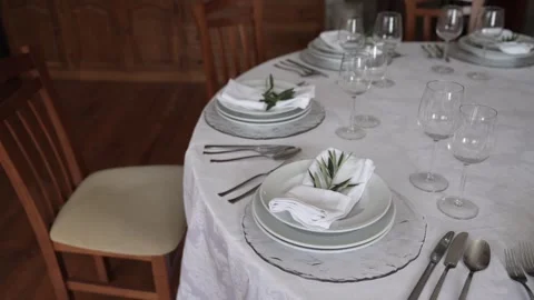 Table set with plates cutlery glasses and folded napkins Video stock 328957308