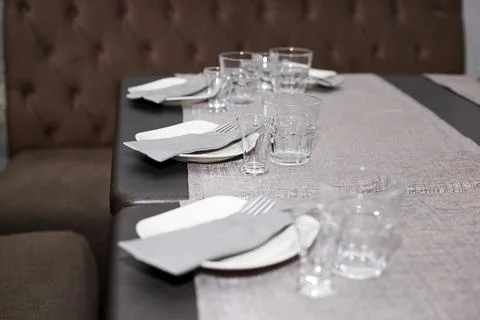 A table set in a restaurant plates, glasses, napkins Stock Photos