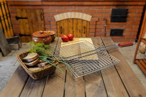 Table set for some outdoor grilling. A metal grill rack is placed on a wood.. Stock Photos
