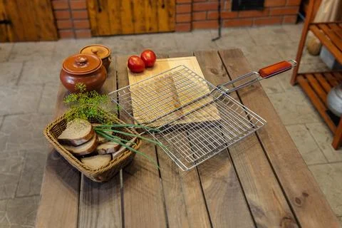 Table set for some outdoor grilling. A metal grill rack is placed on a wood.. Stock Photos