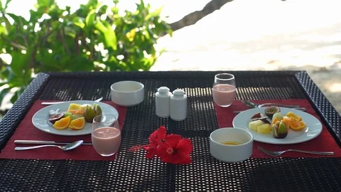 A table set with two breakfasts and people drinking smoothies Stock Footage 101662053