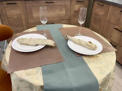 A table set for two with champagne glasses in a modern kitchen. Stock Photos