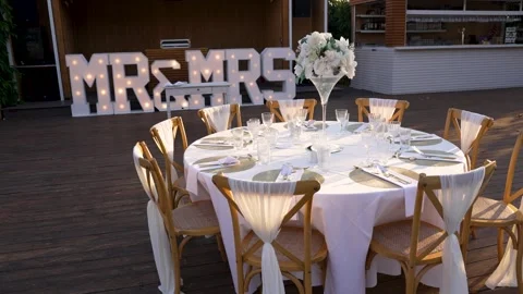 Table set for wedding reception with decorations at outdoor venue in bright Stock Footage 345283952