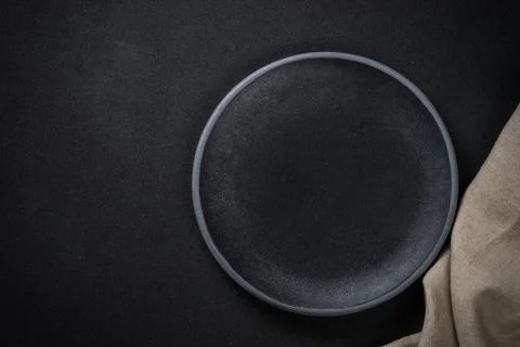Table setting with black plate at black background. Stock Photos