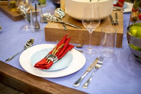 Table setting with a blue tablecloth, a white and blue plate, a red napkin in Stock Photos