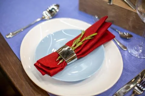 Table setting with a blue tablecloth, a white and blue plate, a red napkin in a Stock Photos