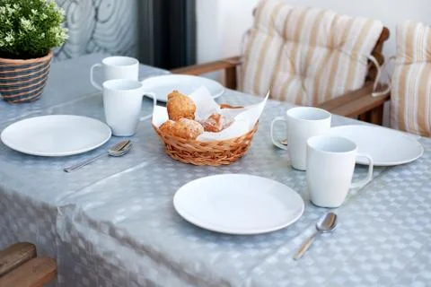 Table setting for breakfast. Pastries, empty cups and plates on a table Stock Photos