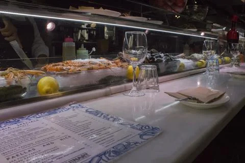 Table setting in a cafe with plates and glasses, at a seafood display case. Foto stock