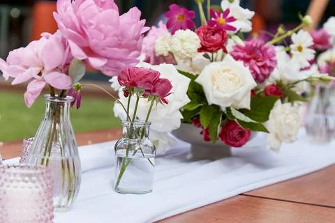 Table setting with candles and textured pink and white flowers. Event decor Stock Photos