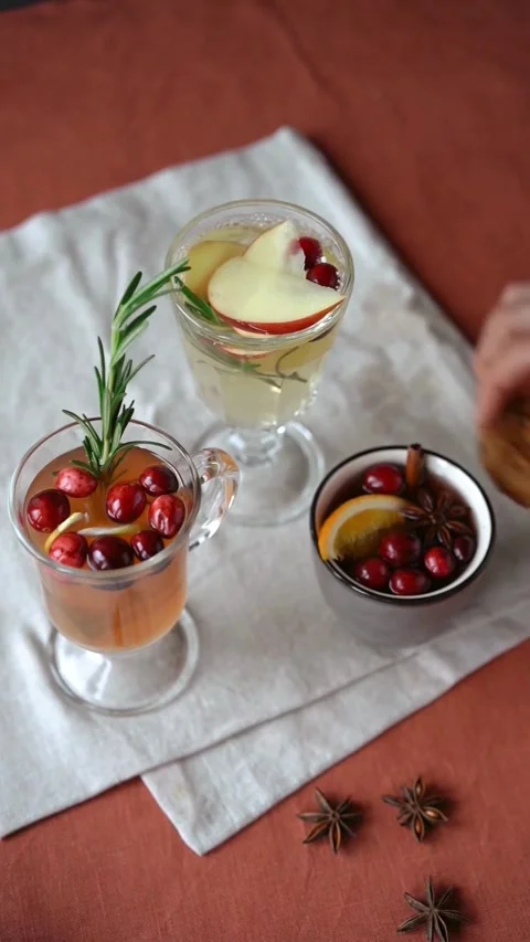 Table setting with cranberry spiced drinks, cinnamon, and cookies Stock Footage 344016874