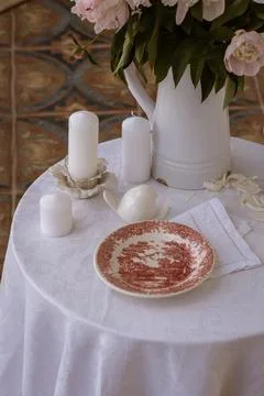 Table setting with a cup of tea and white peonies in a white ceramic jug Stock Photos