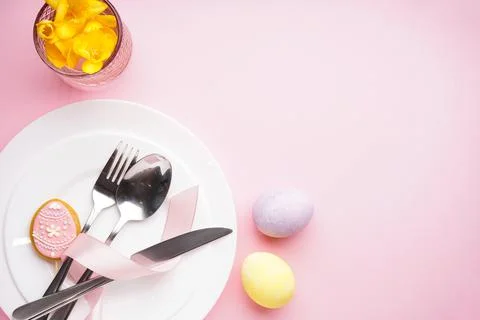 Table setting with cutlery and easter decorations on a pink table. Top view,  Stock Photos