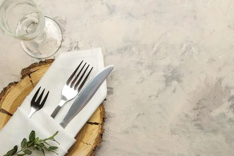 Table setting. cutlery. glass, fork, knife in a white napkin and a wooden sta Stock Photos