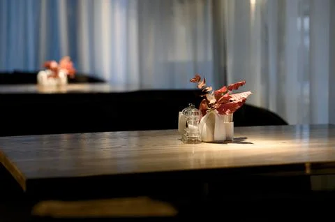 Table setting with decorative flowers and condiments in modern restaurant Stock Photos