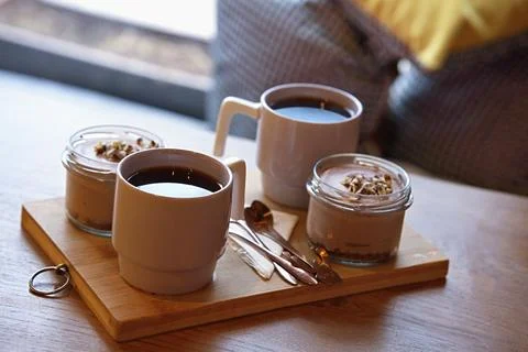 Table setting with desserts and drinks on a wooden board in a cozy cafe Stock Photos