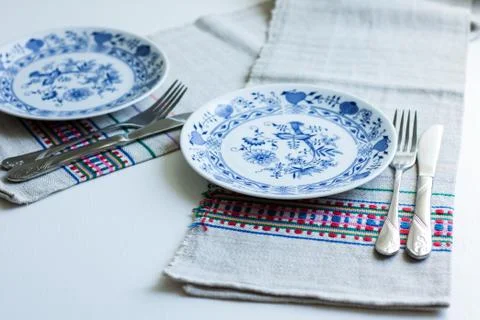 Table setting for dinner: a plate, a fork, a knife on a woven cloth napkin wi Stock Photos
