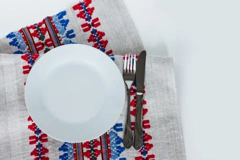 Table setting for dinner: a plate, a fork, a knife on a woven cloth napkin wi Stock Photos