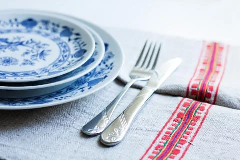 Table setting for dinner: a plate, a fork, a knife on a woven cloth napkin wi Stock Photos