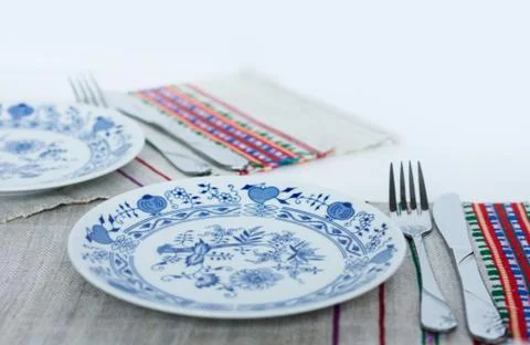 Table setting for dinner: a plate, a fork, a knife on a woven cloth napkin wi Stock Photos