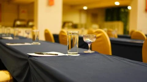 Table setting. Drinking glasses and white papers setup on the table Stock Photos