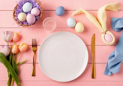 Table setting for Easter feast. Easter eggs, bunny, tulips and cutlery top .. Stock Photos