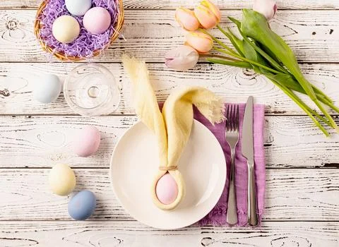 Table setting for Easter feast. Easter eggs, bunny, tulips and cutlery top .. Stock Photos