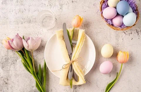Table setting for Easter feast. Easter eggs, bunny, tulips and cutlery top .. Stockfoto's