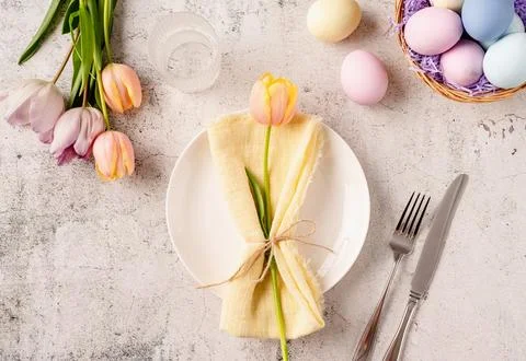 Table setting for Easter feast. Easter eggs, bunny, tulips and cutlery top .. Stockfoto's