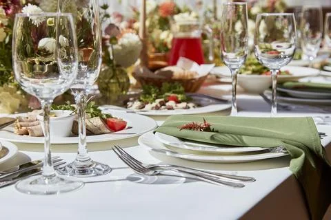 Table setting in elegant chamber is graced by candles and flowers arrangement Stock Photos