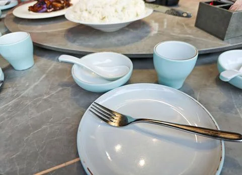 Table setting with empty plates and bowls, featuring a fork, blue ceramic d.. Stock Photos