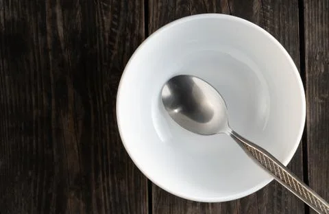 Table setting empty white plate with spoon on wooden table Stock Photos