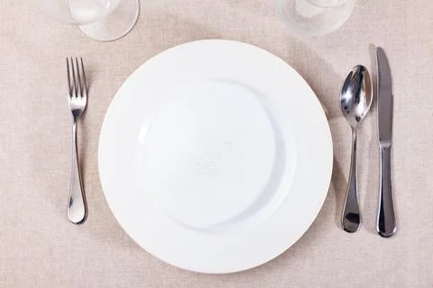 Table setting before festive banquet - plate, knife and fork Stock Photos