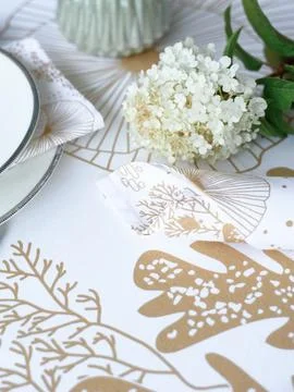 Table setting. Flowers, plates, bright tablecloth with print Stock Photos
