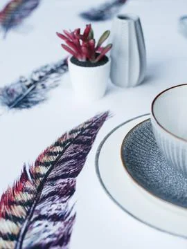 Table setting. Flowers, plates, bright tablecloth with print Stock Photos