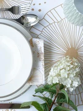 Table setting. Flowers, plates, bright tablecloth with print Stock Photos