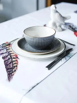 Table setting. Flowers, plates, bright tablecloth with print Stock Photos