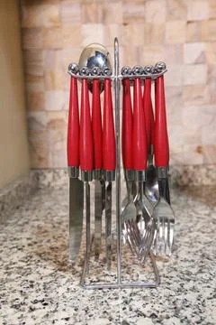 Table setting. Forks, knifes and spoons kept in spoon stand in the kitchen. Stock Photos