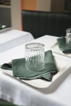 Table setting with glass and napkin in a restaurant Stock Photos