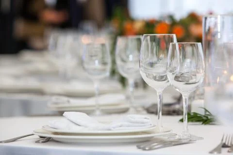Table setting with glasses for different drinks on table on room background Stock Photos