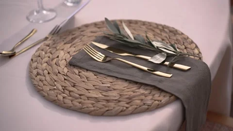 Table setting with gold cutlery and natural elements in a cozy dining space Stock Footage 343035324