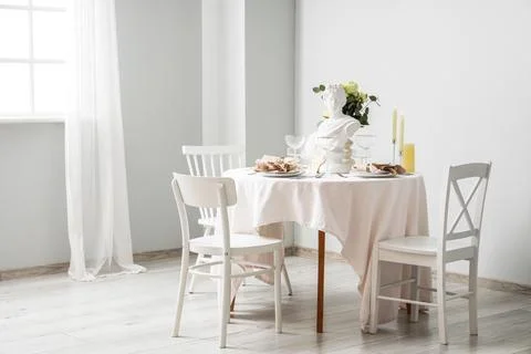 Table setting for Nobel prize day with Greek statuette and roses in light roo Stock Photos