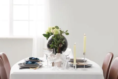 Table setting for Nobel prize day with globe and roses in light room Stock Photos