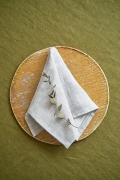 Table setting option. A linen grey napkin is neatly folded on a brown plate Stock Photos