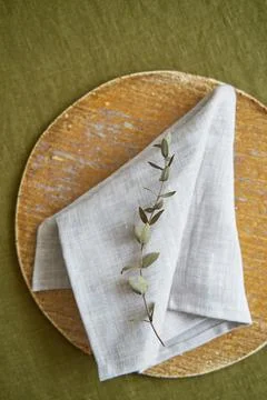 Table setting option. A linen grey napkin is neatly folded on a brown plate Stock Photos