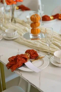 Table setting with orange decorations and white tableware for a gathering d.. Stock Photos