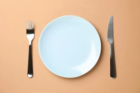 Table setting. Plate, fork and knife on craft background, top view Fotos de archivo
