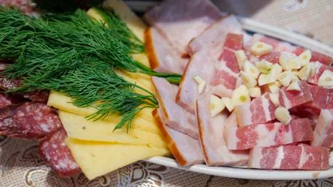 Table setting, pork belly, cheese, smoked sausage and ham cut into slices on an Stock Photos