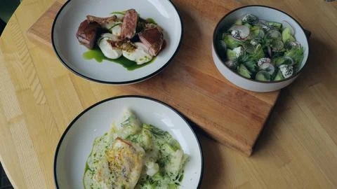 Table setting. Ready meals, meat, fish and vegetable salad on the table, a close Stock Photos