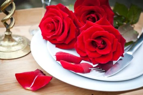 Table setting with red roses on plate - celebrating Valentine's Stock Photos